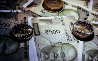 Detailed close-up of Indian currency notes and coins, featuring Mahatma Gandhi portrait. Salon GST