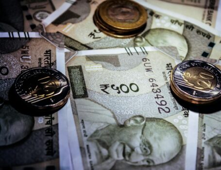 Detailed close-up of Indian currency notes and coins, featuring Mahatma Gandhi portrait. Salon GST
