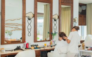 Elegant hair salon interior featuring mirrors, wooden decor, and a hairstylist attending to a client. regeneration in beauty industry