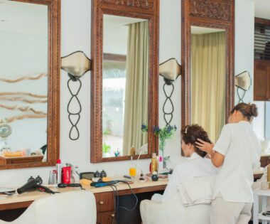 Elegant hair salon interior featuring mirrors, wooden decor, and a hairstylist attending to a client. regeneration in beauty industry